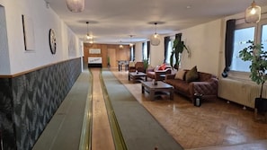A hotel lobby with a long reception desk, seating area with sofas, and a large window with a view. - Hotel Engelskirchen (Engelskirchen)