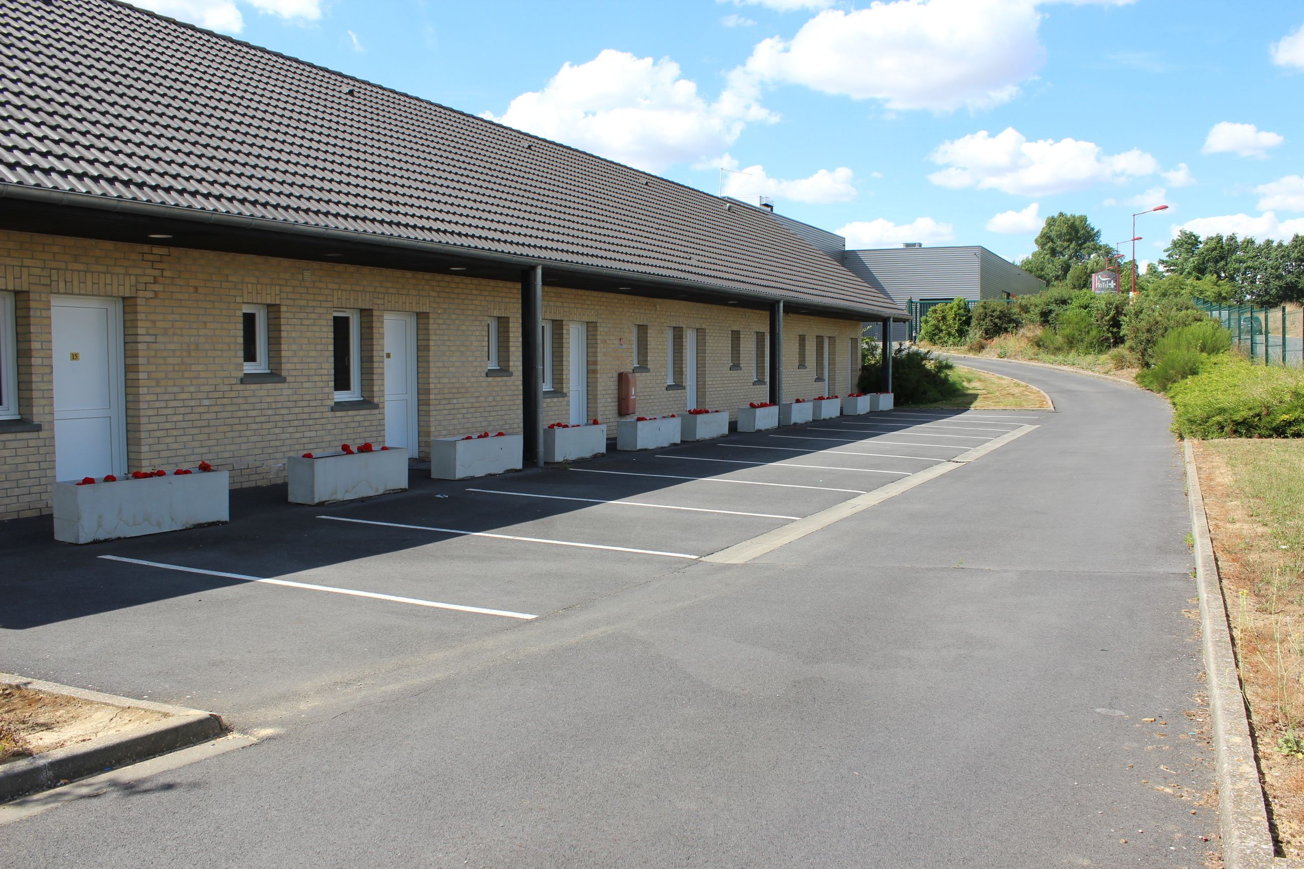 A building with a tiled roof and a row of parking spaces.