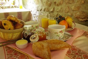 Desayuno con pastelería, miel, mermelada y fruta fresca.