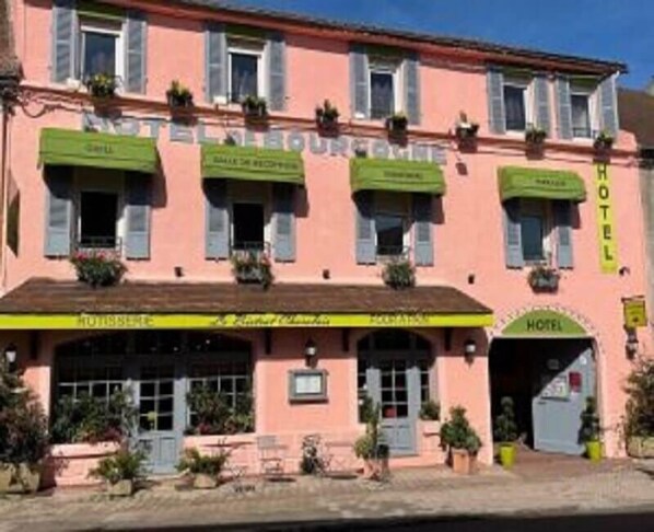 Un edificio rosa con un letrero que dice "HOTEL" y "HOTEL DE FRANCE".