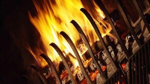Primer plano de un fuego ardiendo en una rejilla metálica.
