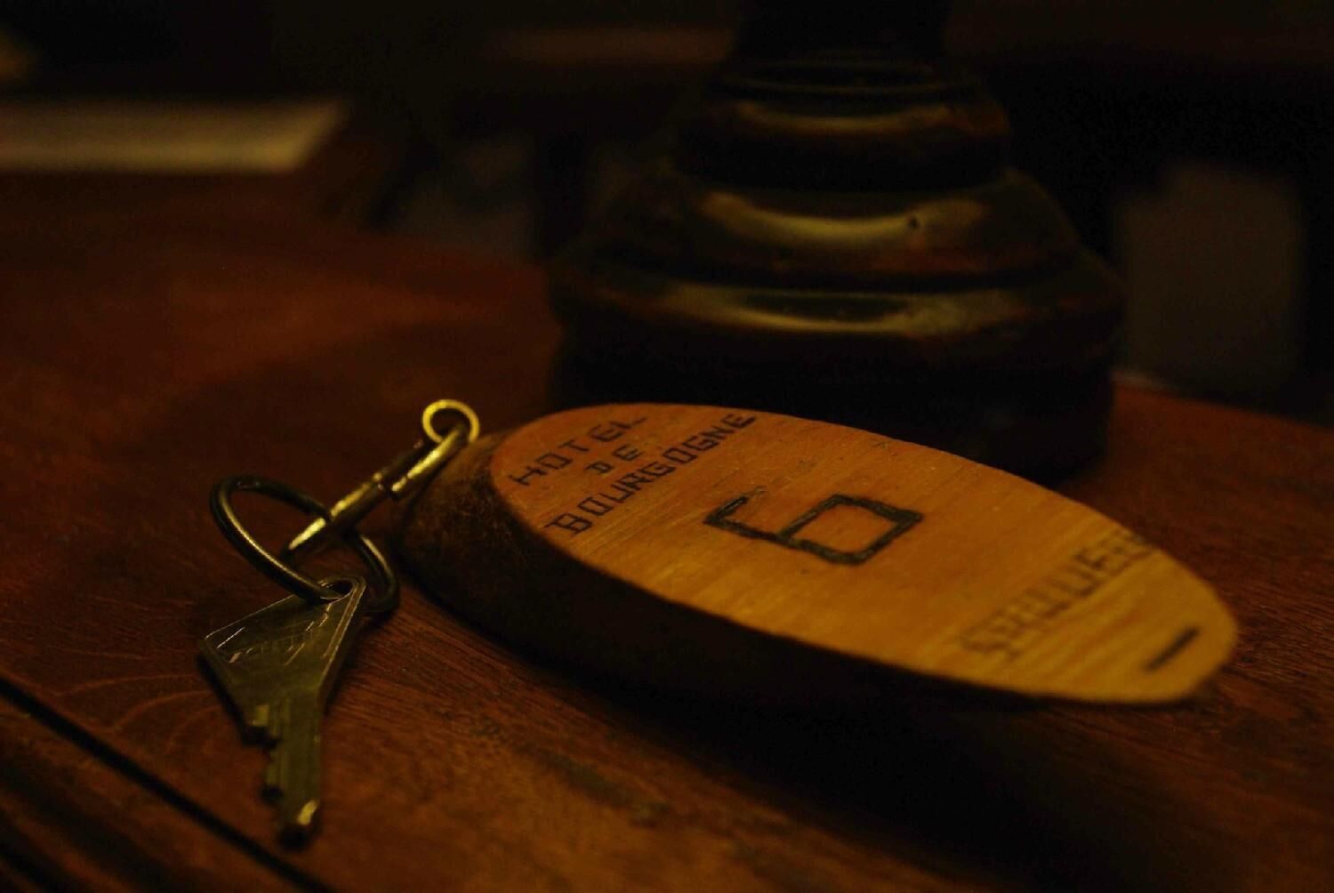 Un llavero de madera con el texto "HOTEL DE BOURGOGNE" y el número "6".