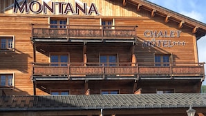 A wooden building with balconies and a sign that reads "MONTANA CHALLET HOTEL". - Montana Chalet Hôtel Spa (Enchastrayes)
