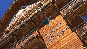 Ein Holzgebäude mit Balkonen und einer Schrifttafel mit der Aufschrift 'MONTANA CHALET HOTEL'.