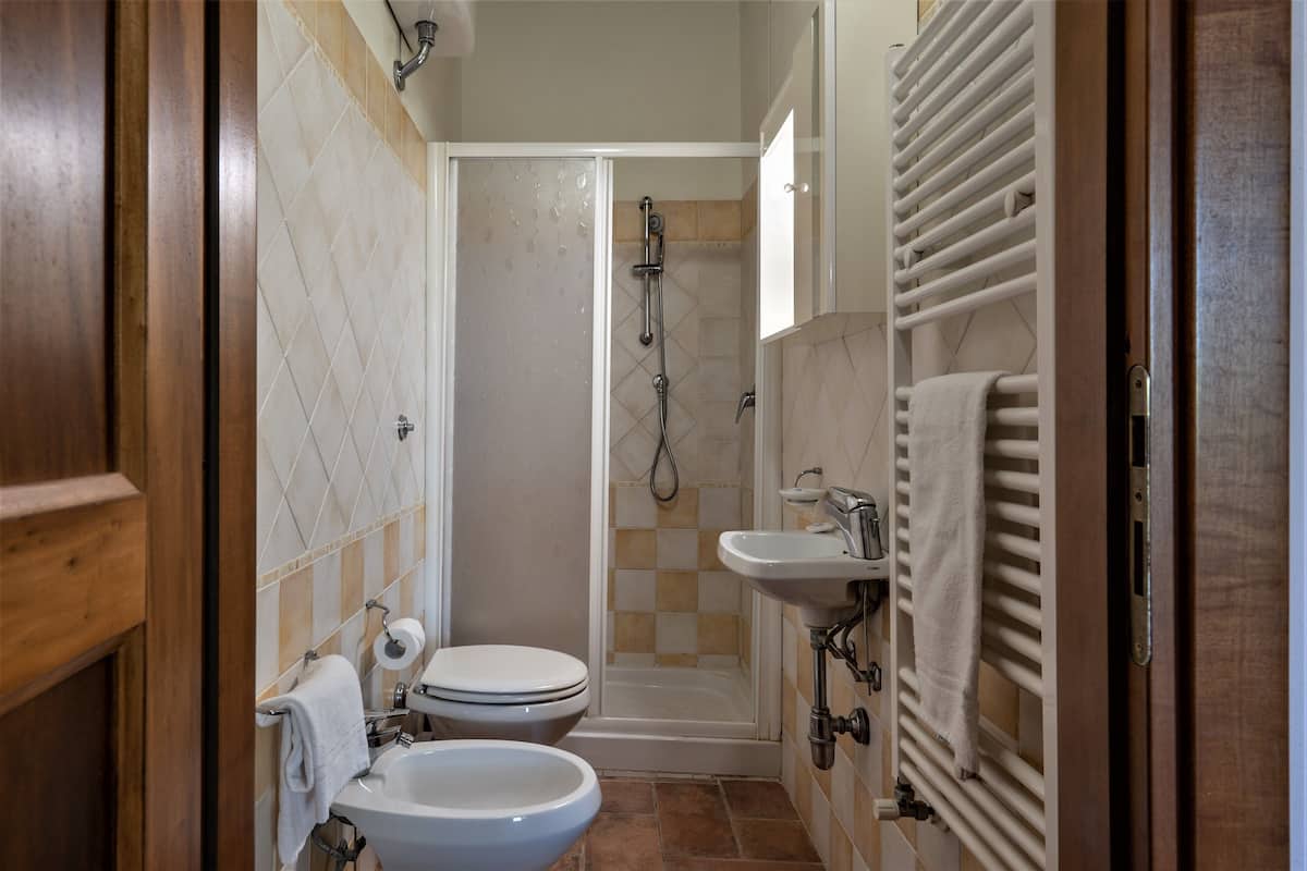 Une salle de bain avec des toilettes, un lavabo et une douche.