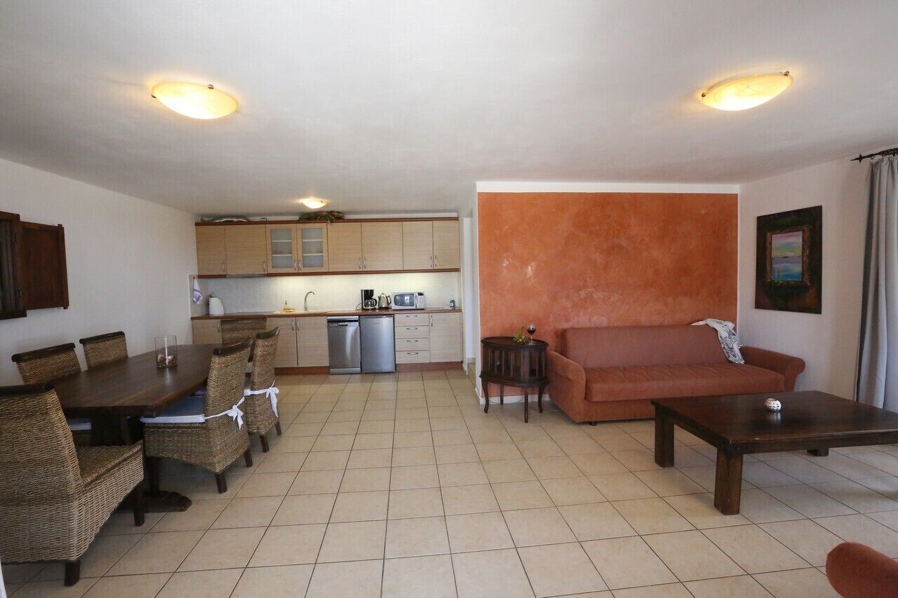 A compact living space with a dining area, kitchenette, and seating area.