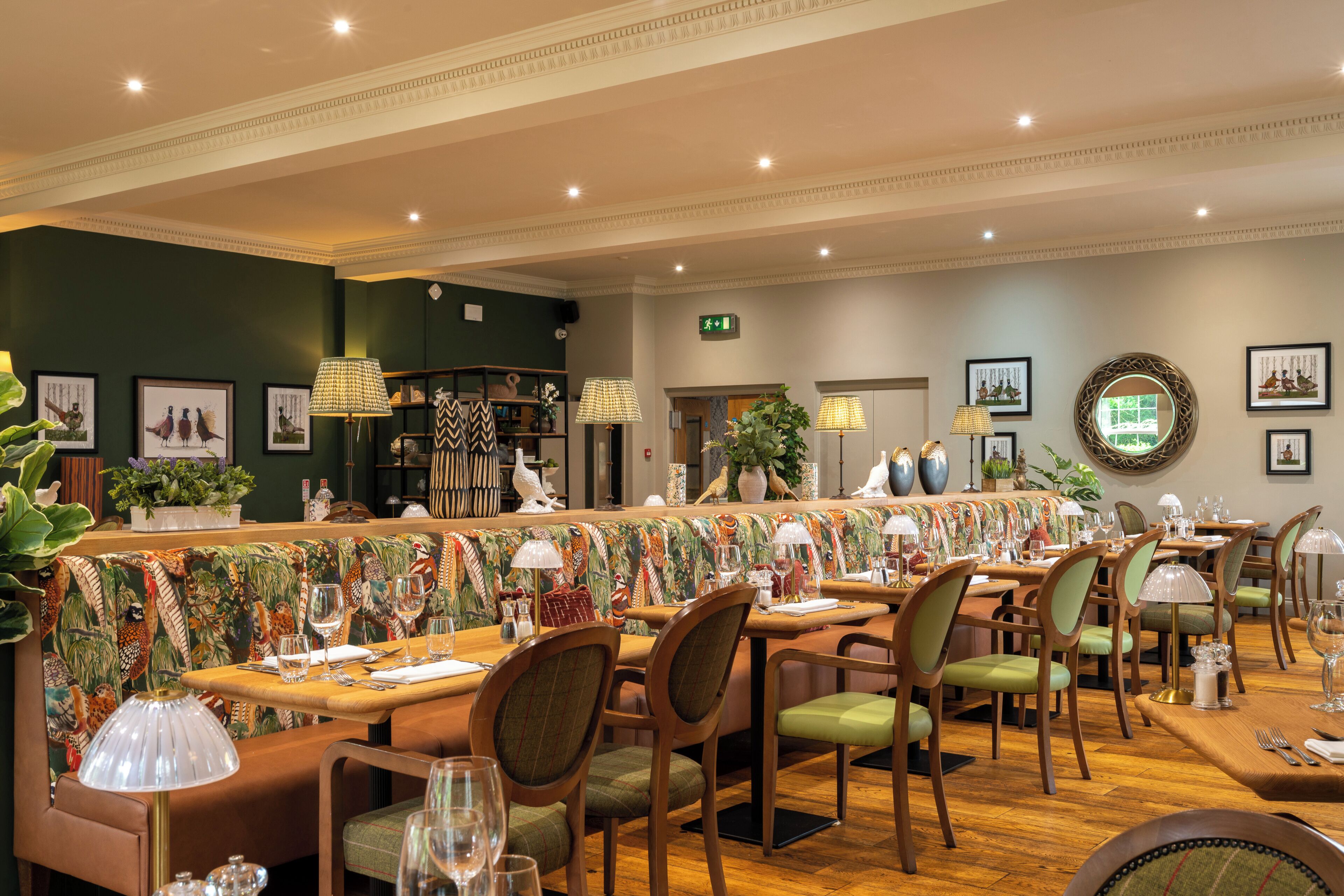 A restaurant with a long counter, multiple dining tables, and chairs.