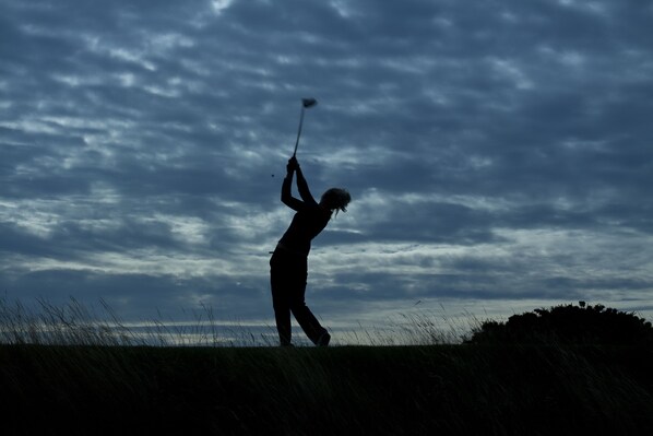 A silhouette of a person playing golf against a cloudy sky. - The Pheasant Hotel, Holt, Norfolk (Holt)