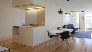 A modern kitchen with a dining area, wooden flooring, and contemporary furniture. - Liiiving In Porto - Central Secret Balcony (Porto)