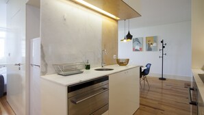A modern kitchen with a built-in dishwasher, a sink, and a wooden countertop. - Liiiving In Porto - Central Secret Balcony (Porto)