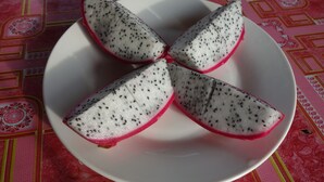 A white plate with four slices of dragon fruit on a tablecloth with a geometric pattern. - Authentic Cambodian Angkor Cottage (Siem Reap)