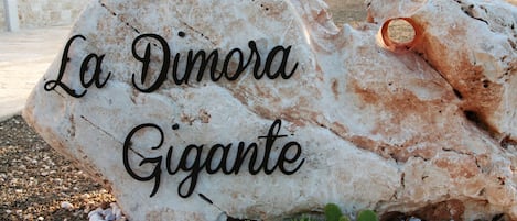 A large rock with the inscription "La Dimora Gigante".