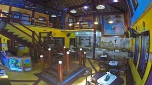 Un restaurant à plusieurs niveaux, doté d’un escalier, de tables et d’un espace cuisine.