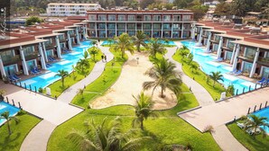 A resort with multiple swimming pools, palm trees, and a large building with balconies.