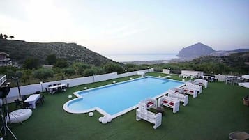 Una piscina al aire libre de temporada, sombrillas