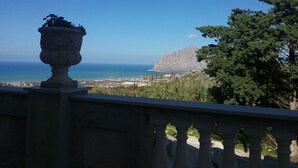 Un balcón con vista al mar y a la montaña.