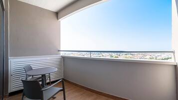 Un balcon avec une table et des chaises, un radiateur et une vue sur la ville.