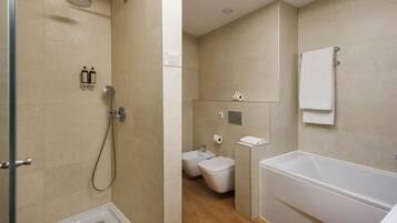 A modern bathroom with a shower, toilet, bidet, and bathtub.