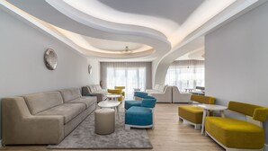 A modern living room with a sofa, armchairs, and a coffee table.