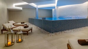 A modern spa area with a hot tub, lounge chairs, and decorative lanterns.