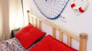 A bed with red pillows, a wooden headboard, a blue net, and a life preserver on the wall. - Apartments on Prospekt Dzerzhinskogo 240 (Novorossijsk)