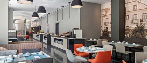 Un restaurant moderne avec de hauts plafonds, des luminaires suspendus et un espace buffet.