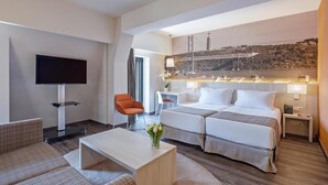 A hotel room with two beds, a TV, a coffee table, and a view of a bridge. - Dorma Liberdade (Lisbon)