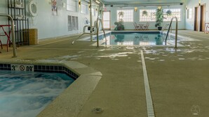 An indoor swimming pool with clear water, safety equipment, and a lifeguard chair. - Newcastle Lodge and Convention Center (Newcastle)