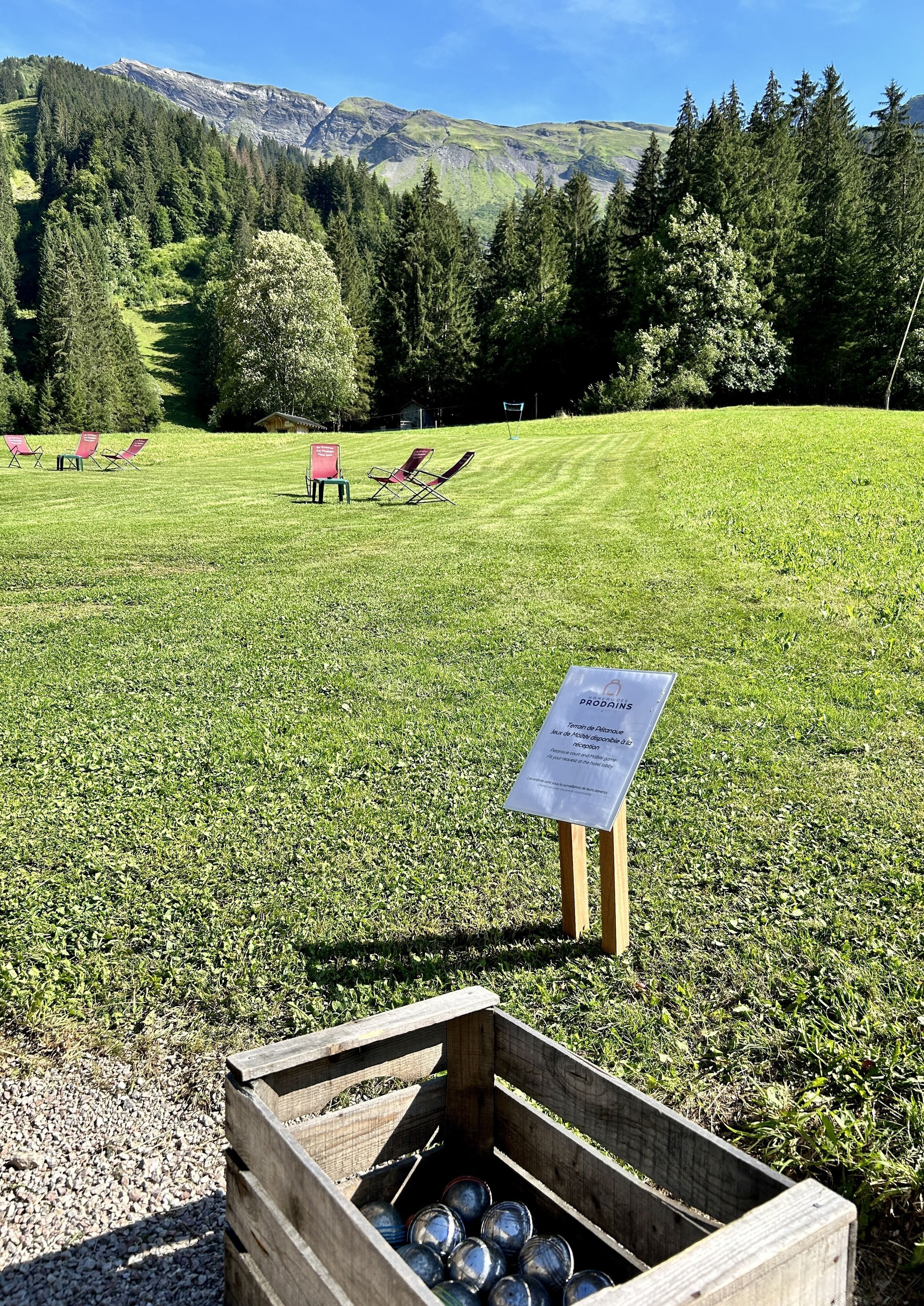 A grassy field with a sign and a wooden crate.
