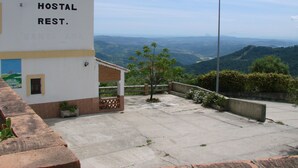A hostel with a sign reading "HOSTAL REST." and a view of the surrounding landscape. - Hostal Breñaverde (Gaucin)