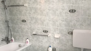 Ett badrum med badkar, bidé och toalett.