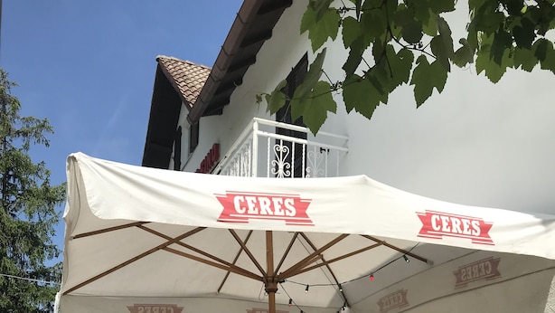 Ett utomhuskafé med bord som är täckta av parasoller märkta med texten ”CERES”.