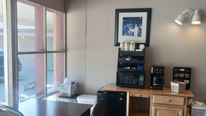 Una kitchenette compacta equipada con refrigerador, microondas, cafetera y alacenas.