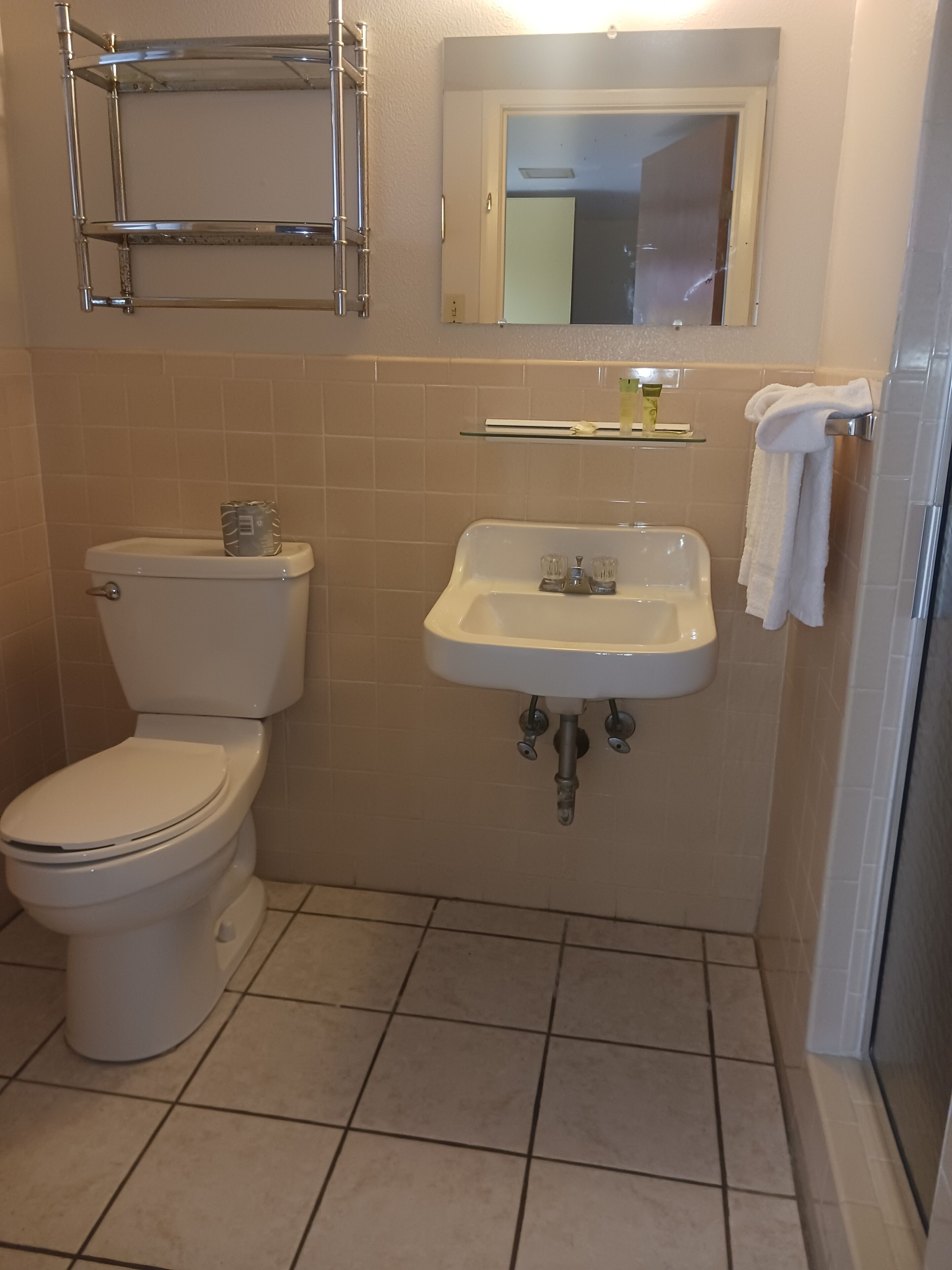 Un baño con inodoro, lavamanos y cabina de ducha de vidrio.