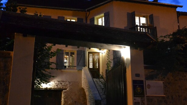A two-story building with a stone facade, a balcony, and a staircase leading to the upper floor. - Chambres D'hôtes Villa de Vienne-en-arthies (Vienne-en-Arthies)