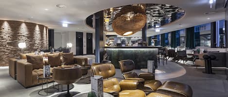 Un hall d’entrée moderne avec des sièges en cuir, un comptoir d’accueil et un design de plafond original.