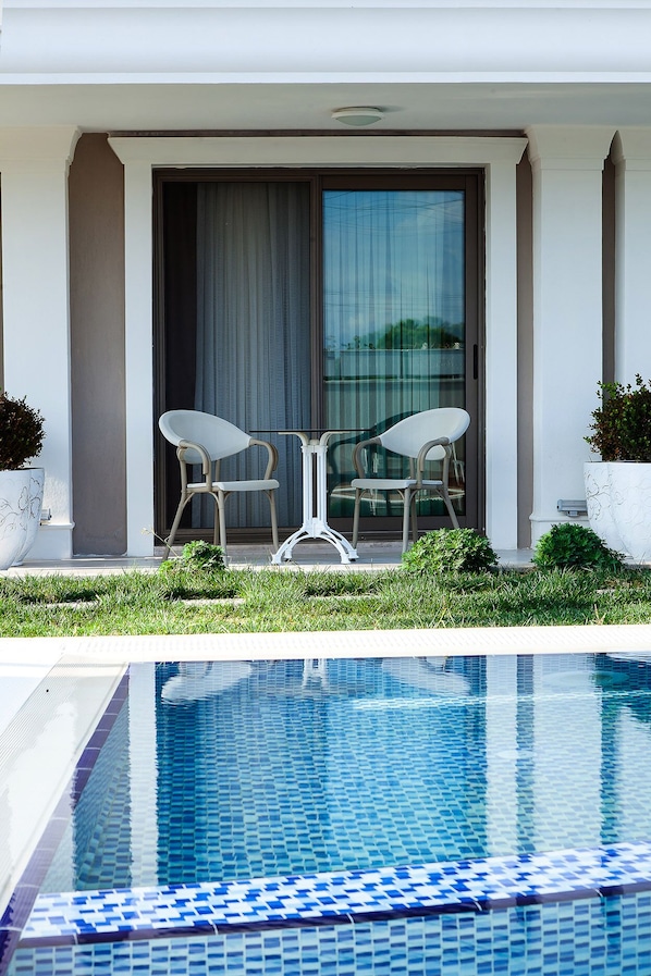 Una piscina al aire libre de temporada, sombrillas