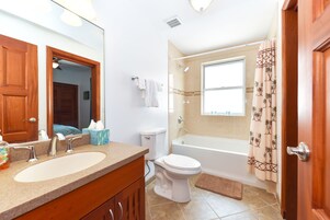 Baño con lavamanos doble, inodoro, bañera y ducha.