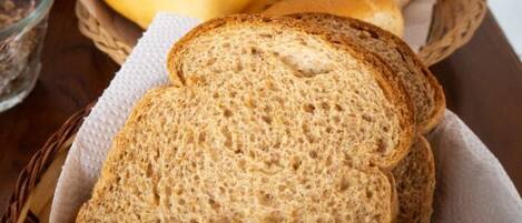 Een mand met sneetjes brood en broodjes op een tafel.