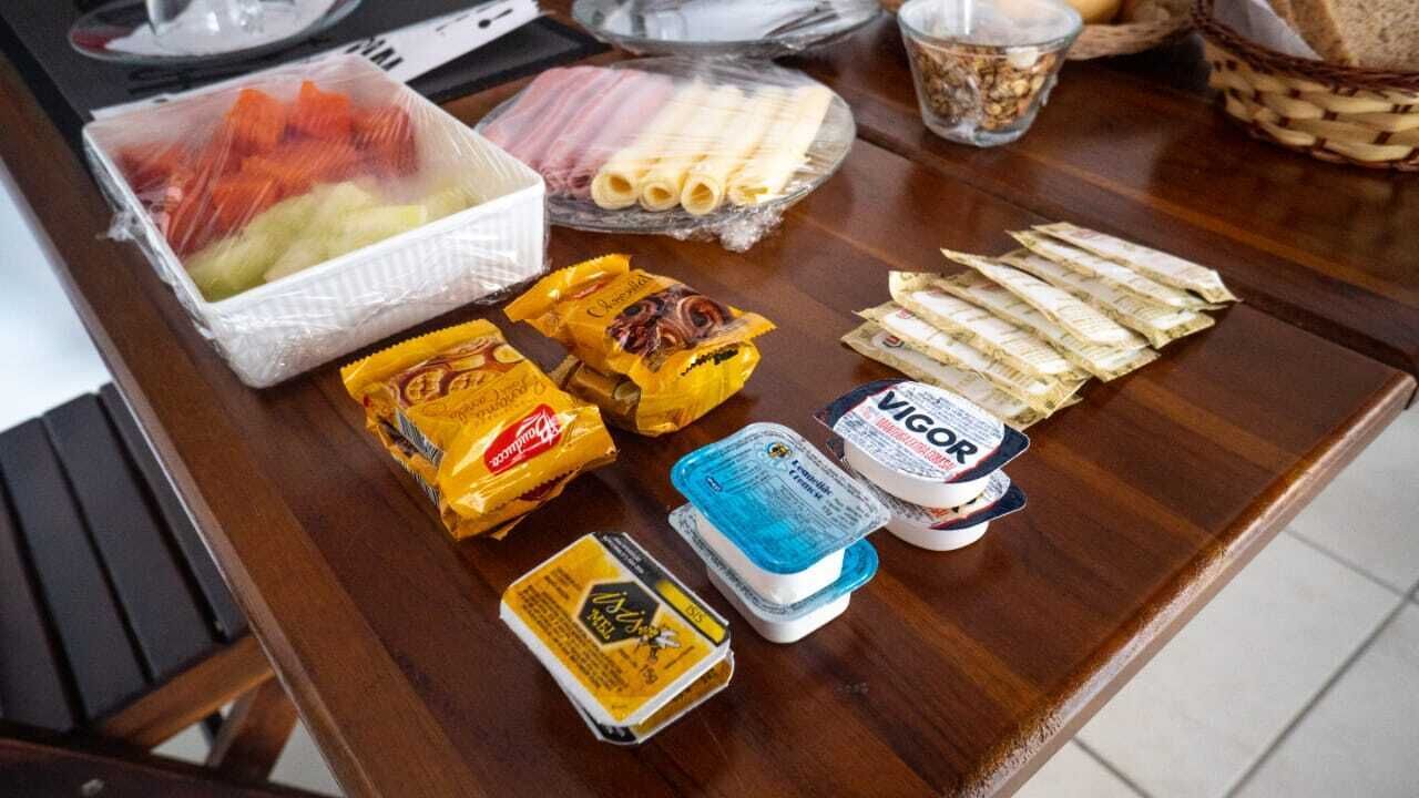 Un bufé de desayuno con diversos alimentos, incluyendo frutas, carnes, quesos y salsas.