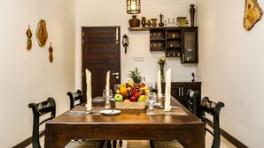 A dining table set with candles, fruit, and wine glasses. - Huluganga Ridge (Teldeniya)