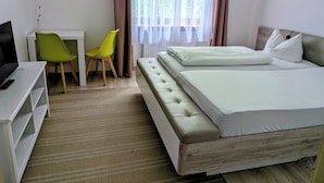 Una habitación de hotel con una cama, un escritorio, una silla y un televisor.