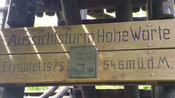 Un letrero de madera con el texto "Aussichtsturm Hohewarte" y "Construido en 1975".