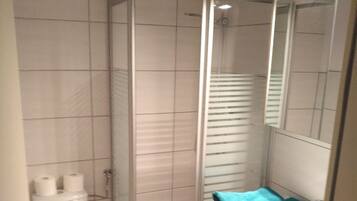 Un baño con inodoro, cabina de ducha y lavabo con espejo.