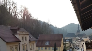 Vista de una calle con edificios, una carretera despejada y la aguja de una iglesia a lo lejos.