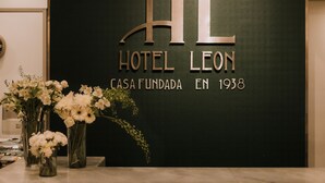 A reception desk with a black wall displaying the text "Hotel Leon" and "Casa Fundada en 1938". - Hotel Leon (León)