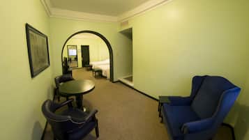 Una habitación de hotel con cama, escritorio, silla y una mesita.