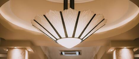 A modern interior with a unique ceiling light fixture and columns.