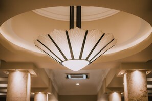A modern interior with a unique ceiling light fixture and columns. - Hotel Leon (León)
