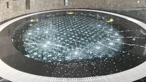 A circular water feature with a central fountain, surrounded by a tiled floor and a curved ceiling. - Sky D'Mont Suites (Genting Highlands)